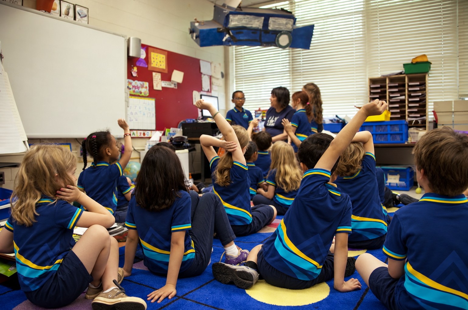 Learners in school uniform participating in a classroom lesson