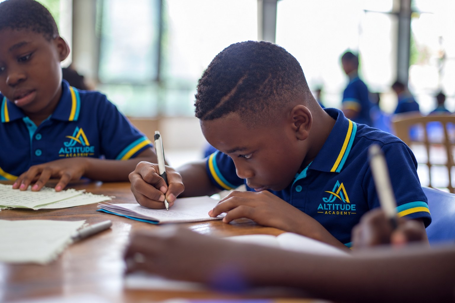 Learners writing at a shared table