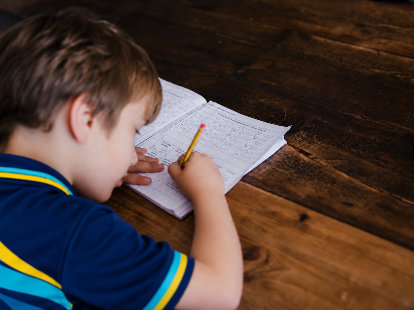 A learner writing in a workbook